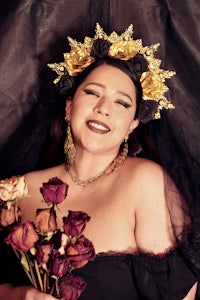 a woman in a black dress holding roses