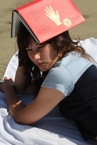 a woman with a book on her head